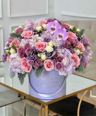 mixed flower arrangement of purple flowers in a lavender box vase