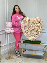 Mujer sosteniendo un corazón hecho de rosas