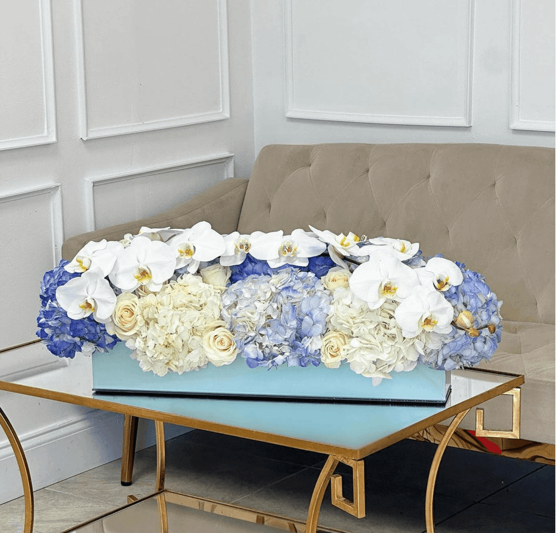 Florero de flores azules y blancas