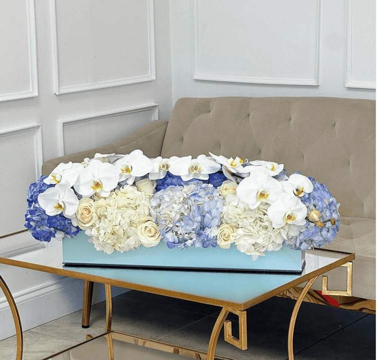 Florero de flores azules y blancas