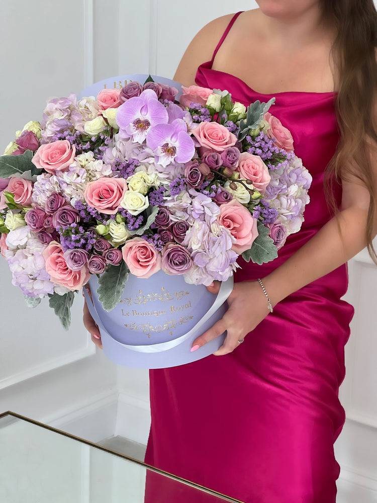a woman holding flower arrangement with roses and other flowers