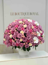 Luxury arrangement of lavender roses, pink spray roses, ivory roses, and white orchids in an elegant vase by Le Boutique Roya