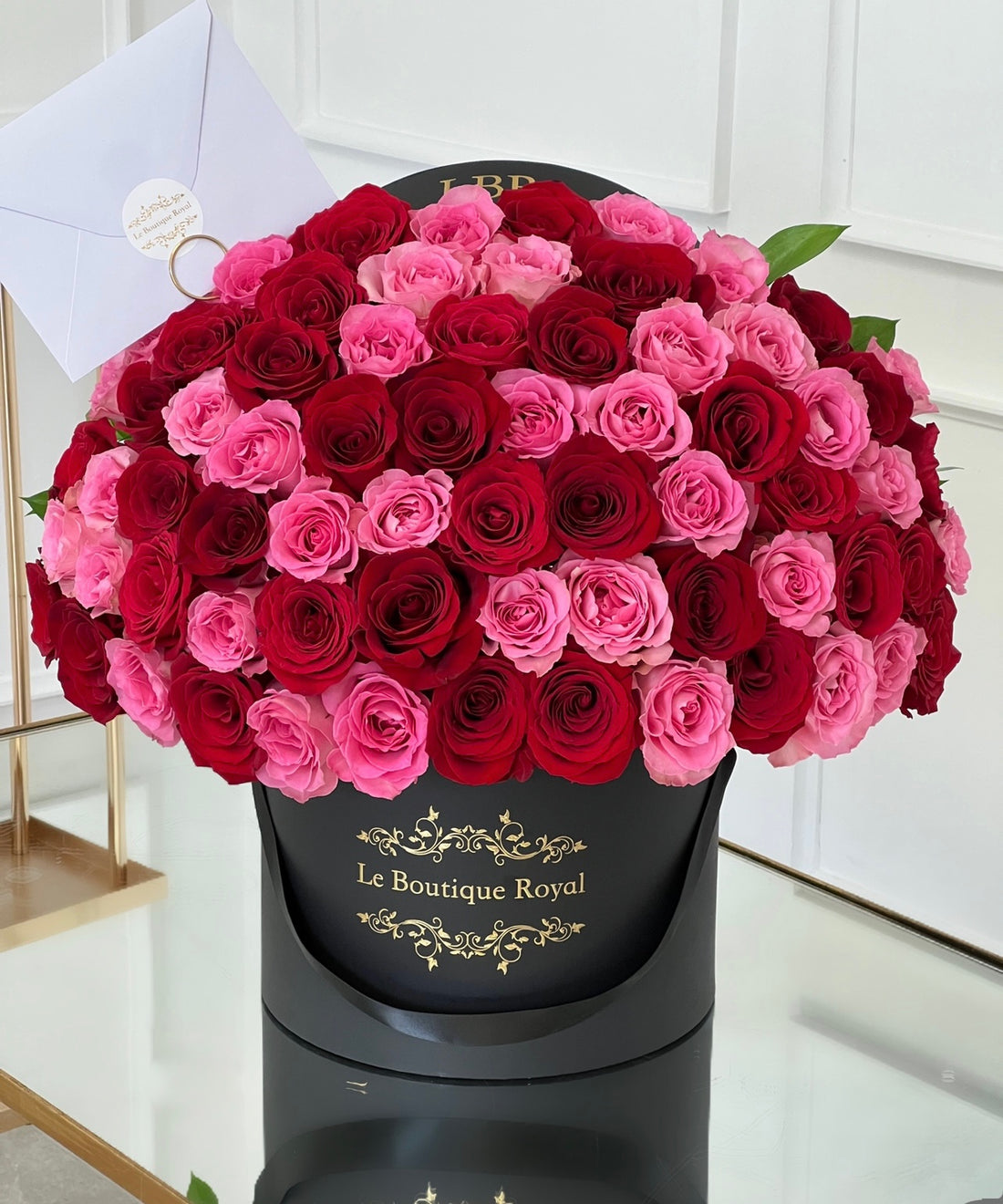 red and pink roses in a black vase