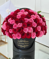 red and pink roses in a black vase