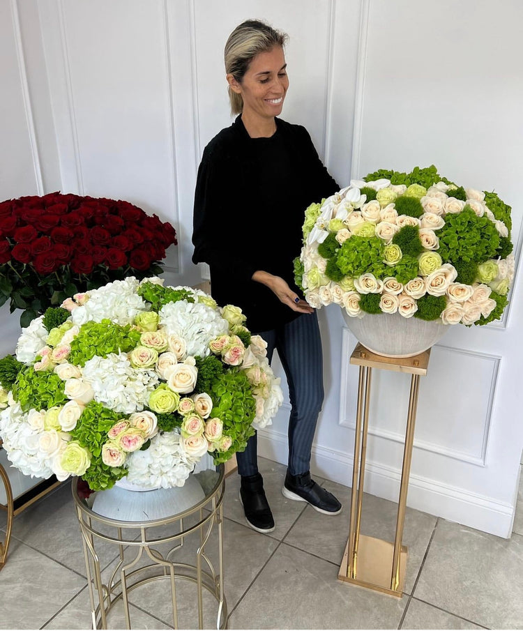 Una persona junto a flores verdes y blancas