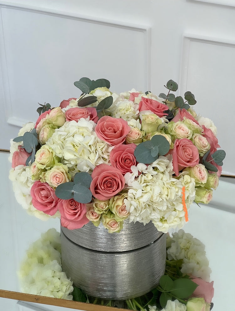 pink and white flowers in a silver vase