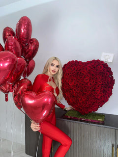 
                    
                      Una modelo junto a un corazón de rosa roja de lujo
                    
                  