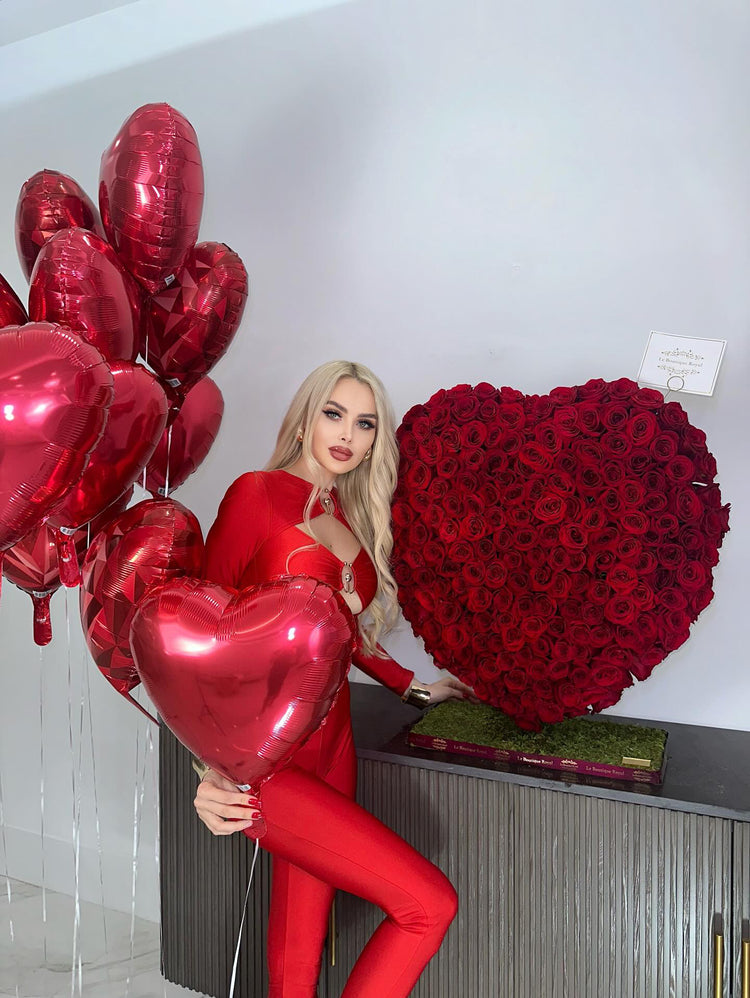 Una modelo junto a un corazón de rosa roja de lujo